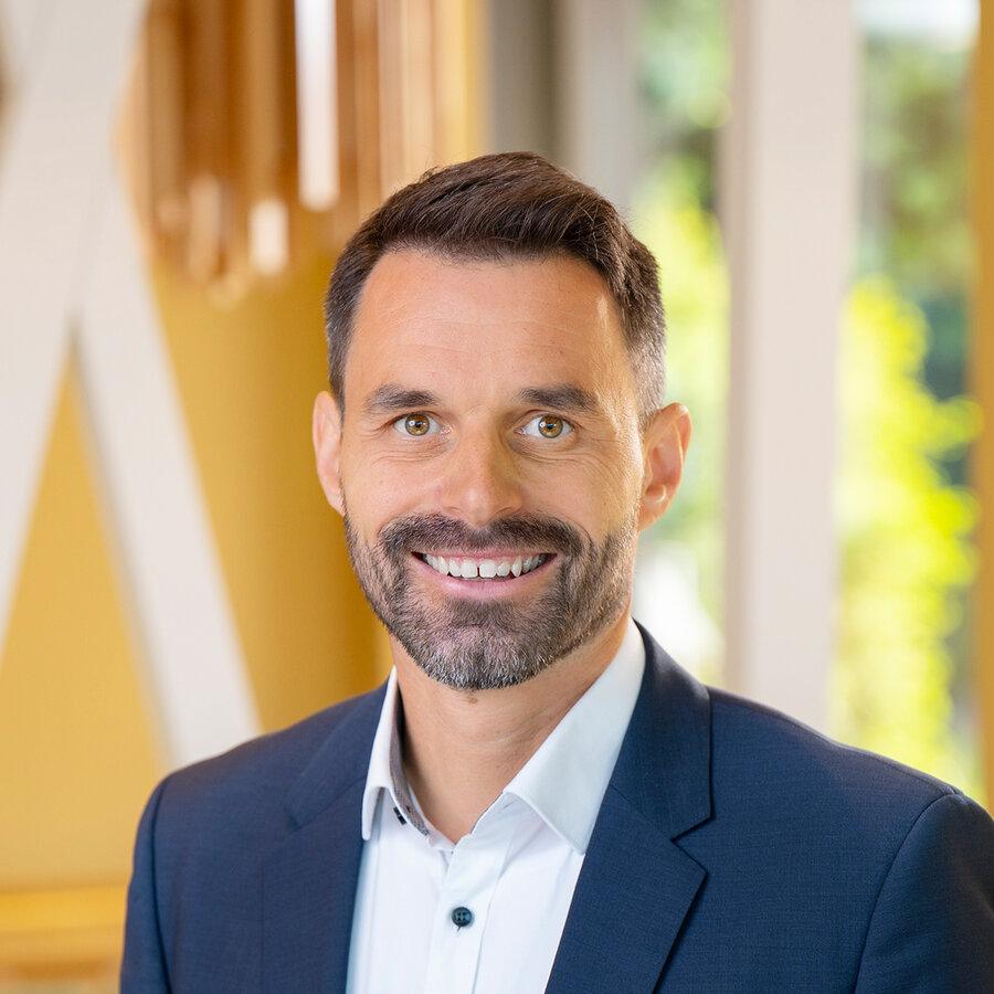 Mitarbeiter im dunkelblauen Anzug als Ansprechpartner für Nachhaltigkeit bei Knoll Bau.