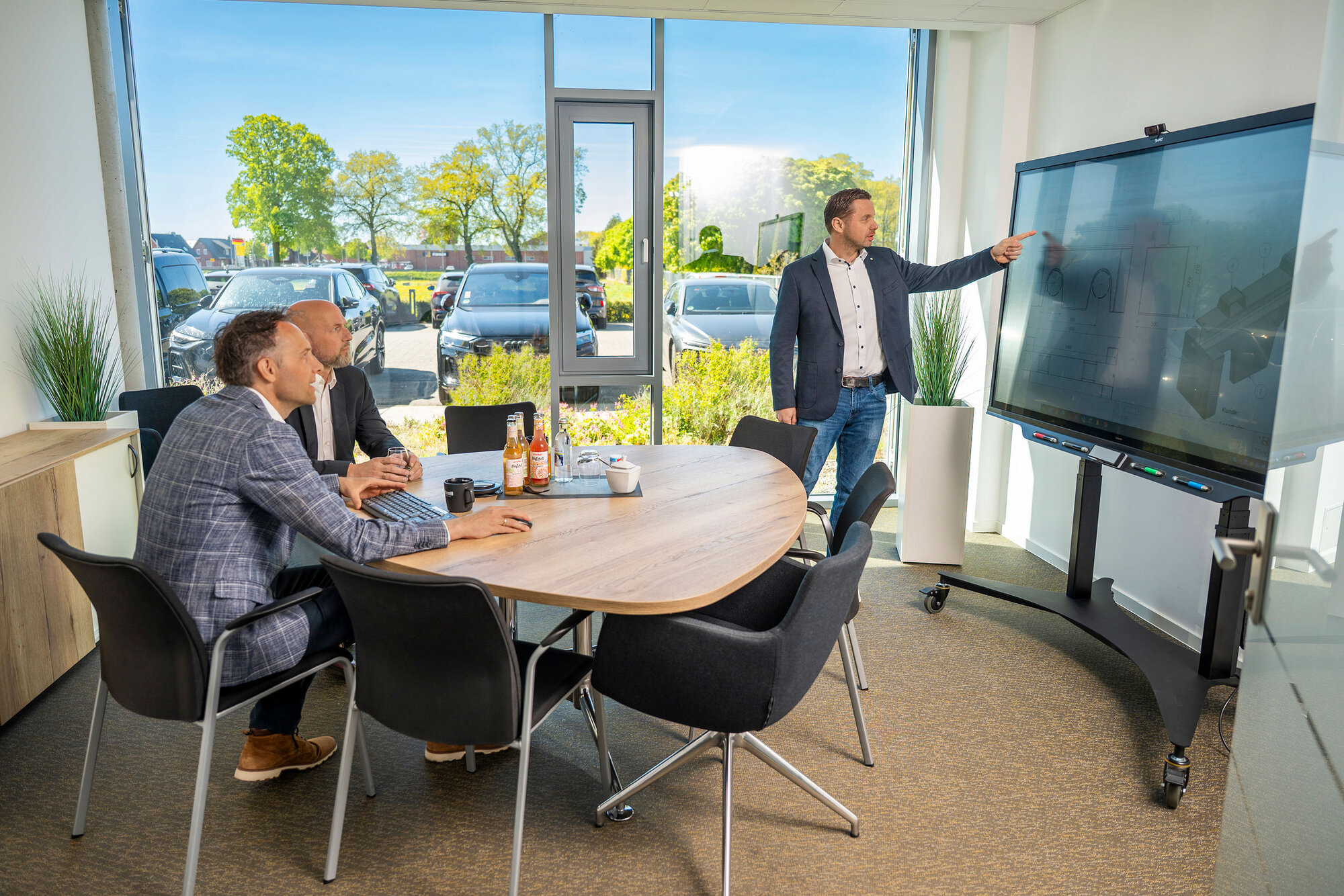Präsentation am interaktiven Bildschirm: Knoll-Bau-Projektpartner verfolgen Pläne im lichtdurchfluteten Konferenzraum.