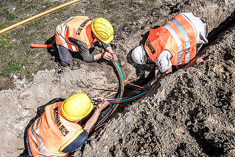 Knoll Bauarbeiter bei Infrastrukturmaßnahmen Verlegung von Kabel in der Erde