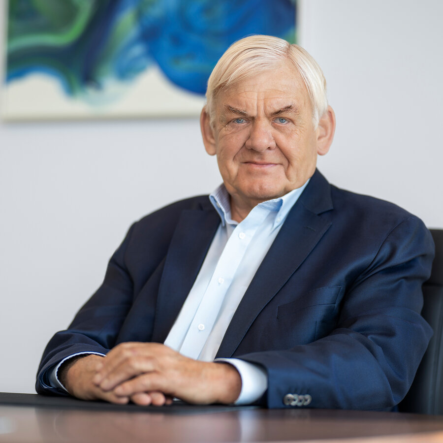 Dr. Knoll im Business-Outfit am Besprechungstisch im Unternehmensbüro