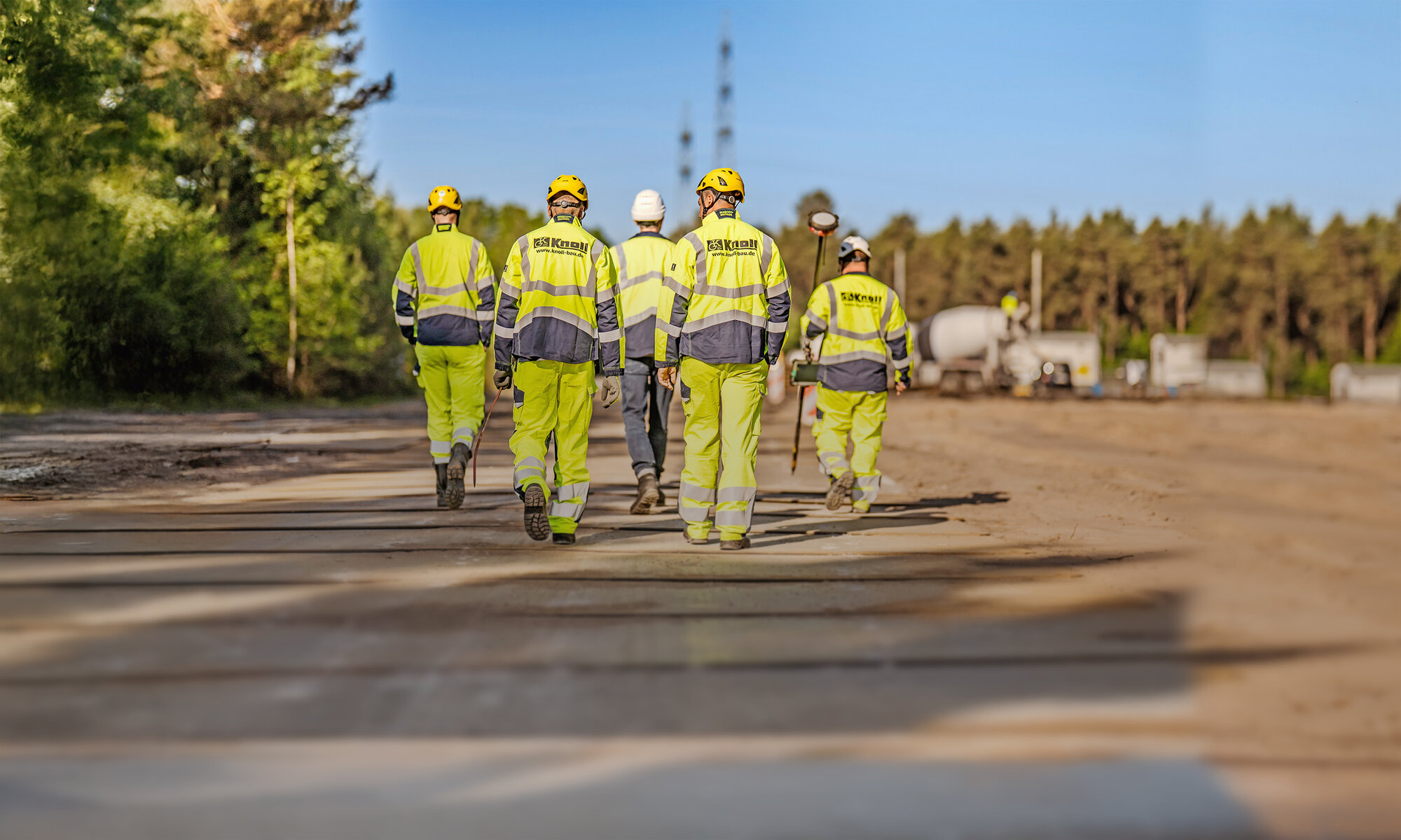Fünf Mitarbeitende der Knoll GmbH gehen gemeinsam über eine Baustelle.