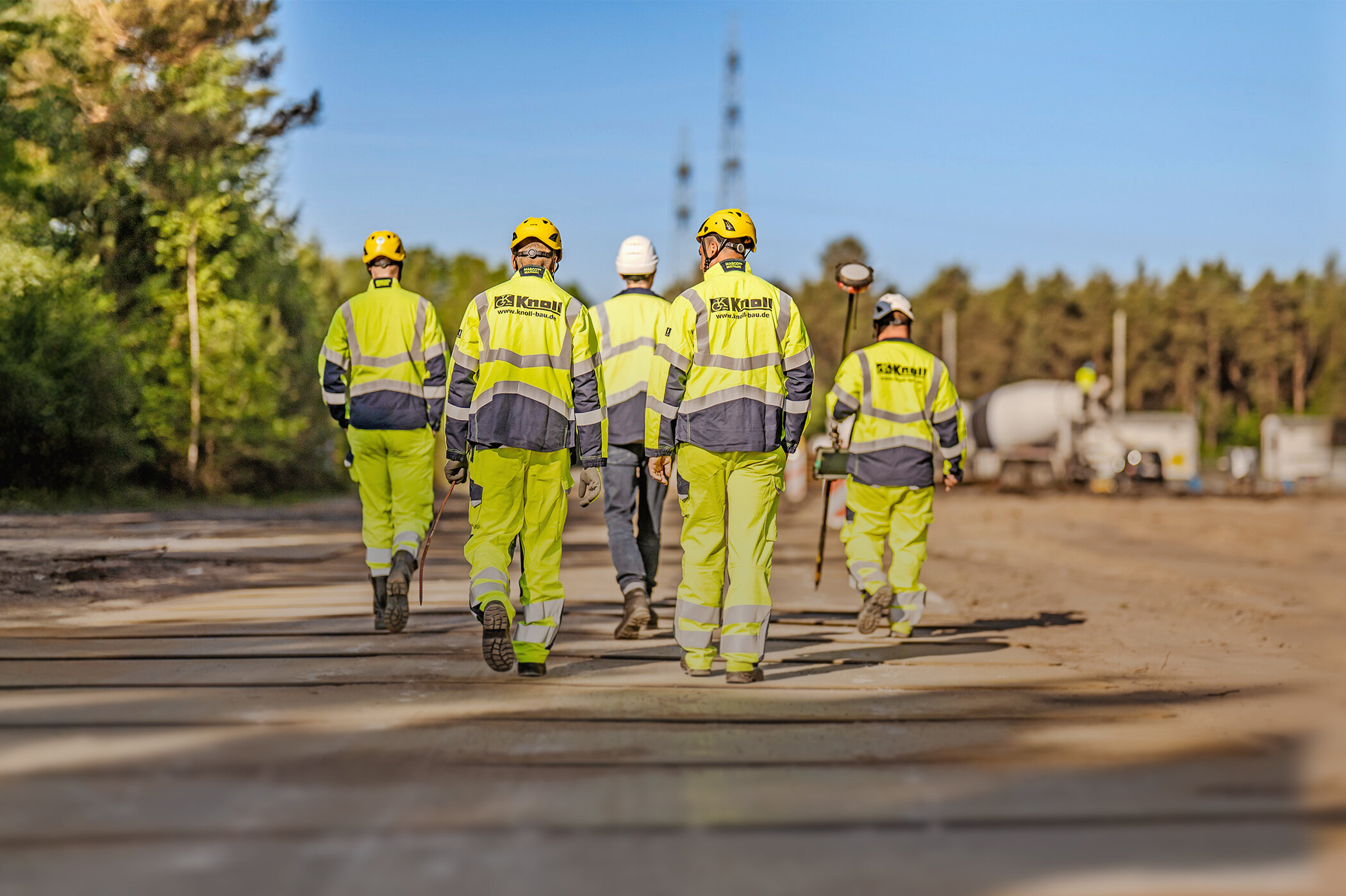 Fünf Mitarbeitende der Knoll GmbH gehen gemeinsam über eine Baustelle.